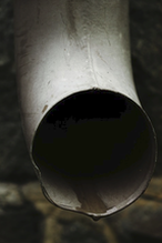 A drainpipe or downspout with a drip of water on it. A photo for a Gutter Cleaning Nanaimo company website.